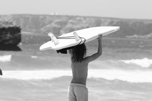 jeune surfeur devant les vagues avec sa board sur la tete 