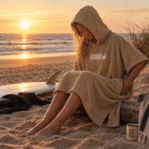 Poncho de surf en coton bio HONO porté par une femme sur la plage
