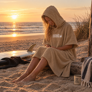 Poncho éco-responsable  camel en coton bio unisexe  HONO porté par une femme sur la plage surfwear bio