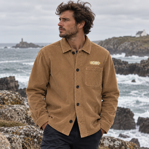 Surchemise HONO en velours  bio côtelé camel portée par un homme face à la mer, dans une ambiance naturelle et authentique du Finistère.