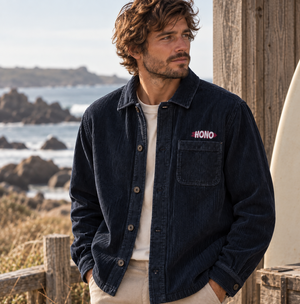 Surchemise navy en velours bio  brodée HONO surfwear portée par un homme en bord de mer