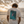 T-shirt surf blanc HONO x Gwendoline Le Ray avec illustration Wild Child Salty Mind dans le dos, porté face à l’océan au coucher du soleil
