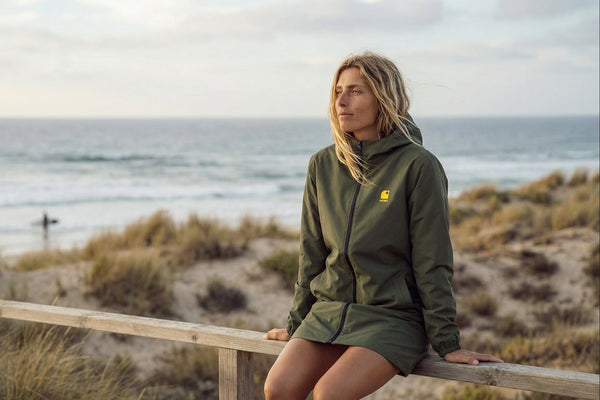 Femme portant veste imperméable HONO kaki recyclée au bord de mer