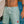 Boardshort recyclé HONO vert d'eau porté par un surfeur dans l'océan, surfwear durable inspiré de l'océan.