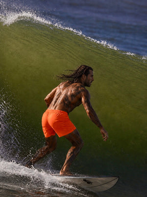 Boardshort homme paprika HONO porté par un surfeur dans une vague, vêtement de surf durable et éco-responsable