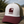 Casquette trucker recyclée HONO avec logo brodé bordeaux, panneau avant blanc, visière bordeaux et arrière en mesh kaki recyclé, photographiée en extérieur sur une table en bois.