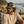 Homme portant une casquette trucker HONO kaki avec filet beige et logo Wave brodé noir, photographié sur un sentier côtier face à l'océan dans une ambiance surf lifestyle naturelle.