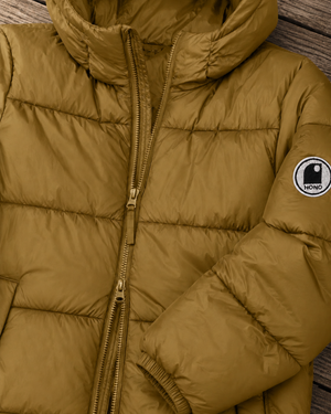 Détail doudoune chaude en nylon recyclé HONO Surfwear bronze, double zip et logo brodé sur la manche