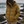 Doudoune chaude en nylon recyclé HONO Surfwear bronze portée par une femme sur la côte, face à l’océan