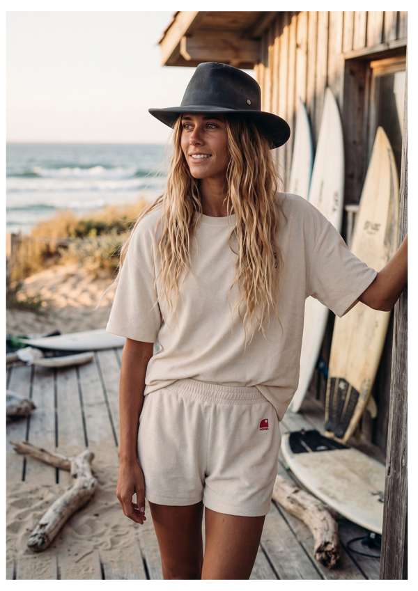 Ensemble surf femme HONO ivoire avec t-shirt et short en coton biologique en bord de mer