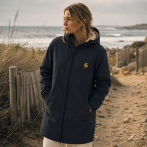 Imperméable recyclé bleu marine HONO porté par une femme, doublé en polaire recyclée, broderie jaune, vêtements de surf surfwear durable et éco-responsable, marque française