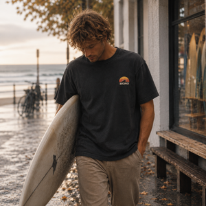 T-shirt surf homme HONO Surf noir vintage en coton bio, marque de surf française éco-responsable, porté près de l'océan
